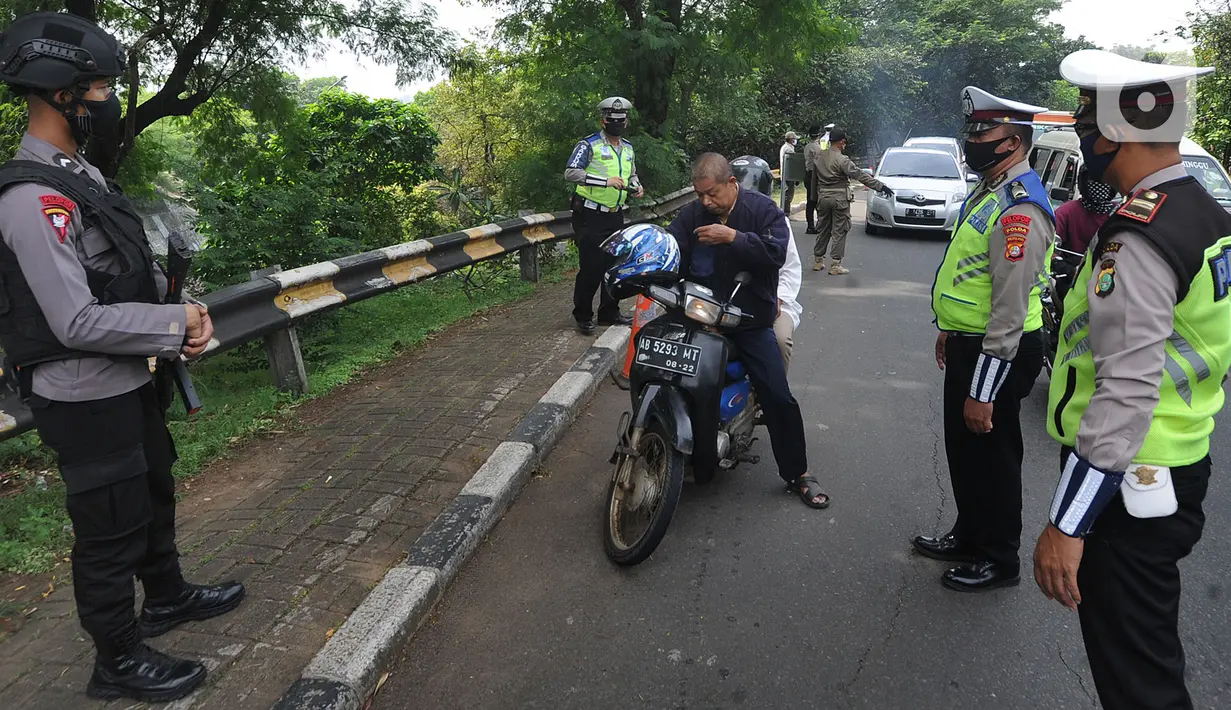 Petugas gabungan memberhentikan pengendara motor yang tidak memakai masker saat penyekatan kendaraan menuju Jakarta di Kelapa Dua, Jagakarsa, Jakarta Selatan, Rabu (27/05/2020). Pemprov DKI Jakarta menerapkan pengetatan bagi para calon pendatang usai mudik Lebaran 2020. (merdeka.com/Arie Basuki)