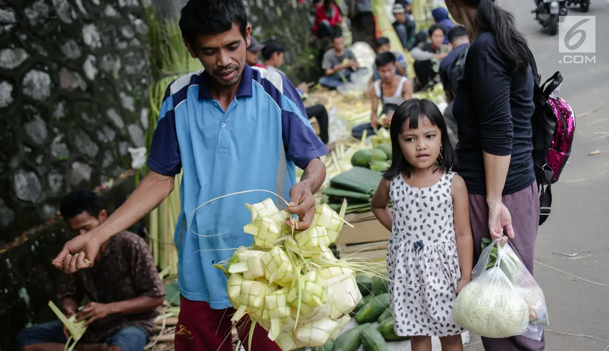 Seorang pria usai membeli kulit ketupat di Pasar Palmerah, Jakarta, Senin (2/6/2019). Peningkatan drastis dikarenakan banyak warga yang ingin membuat masakan khas Lebaran seperti Opor Ayam yang selalu ditemani ketupat sebagai pengganti lontong. (Liputan6.com/Faizal Fanai)