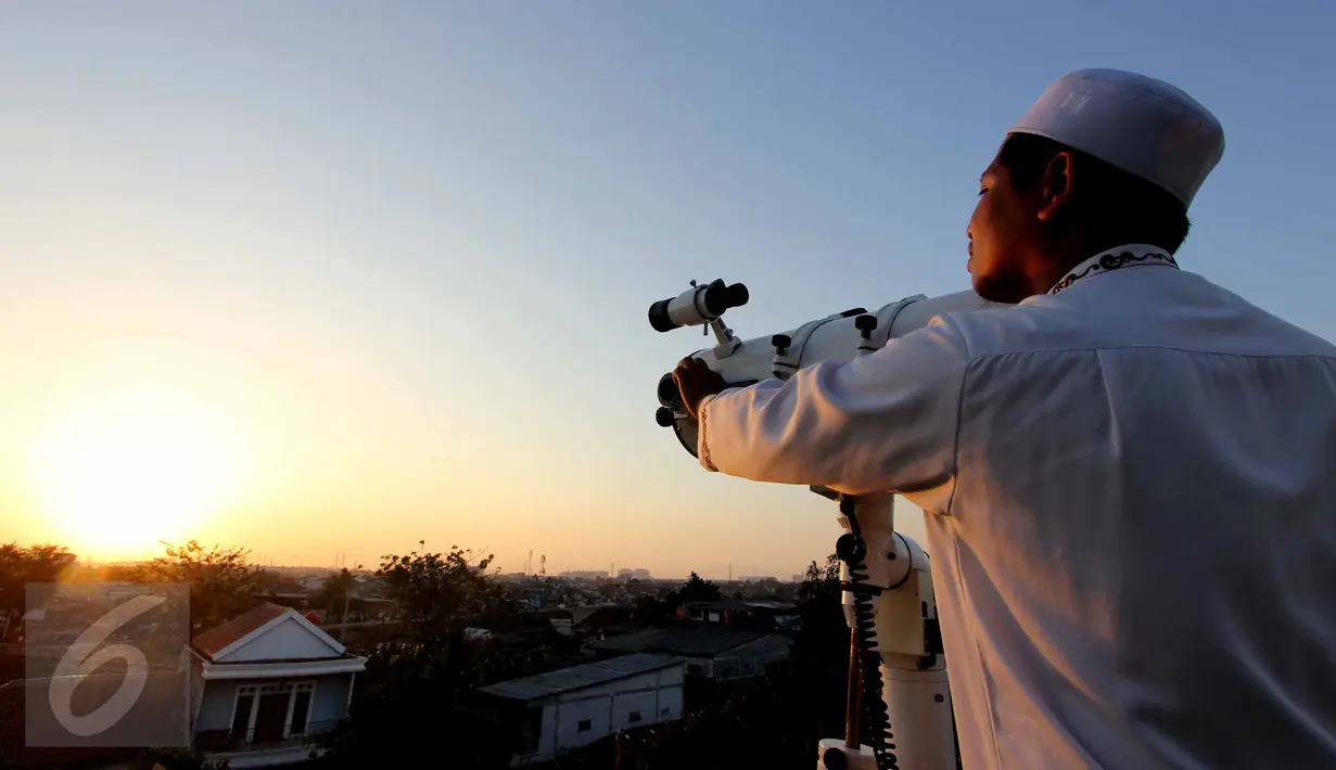 Seorang anggota tim Rukyatul Hilal gabungan meneropong posisi hilal di atas Mesjid Al Musriyiin, Jakarta, Kamis (16/7/2015). Berdasarkan data astronomis ketinggian hilal saat matahari terbenam sekitar tiga derajat. (Liputan6.com/Helmi Afandi)