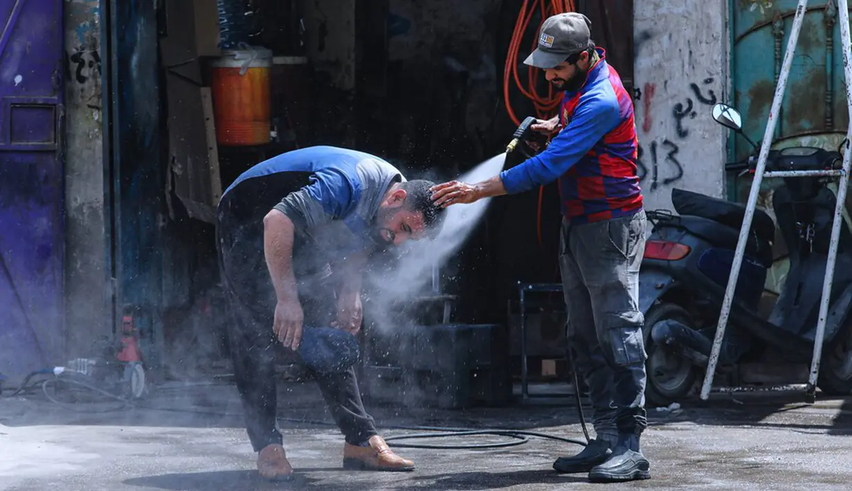 Seorang pria mendinginkan diri dari cuaca panas ketika suhu mencapai 123,8 F (51 C) di Basra, Irak, Kamis (1/7/2021). Pemerintah Irak menetapkan 1 Juli 2021 sebagai hari libur resmi di Baghdad karena gelombang panas yang menyengat. (AP Photo/Nabil al-Jurani)