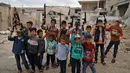 Anak-anak berfoto dengan senapan mainan dekat reruntuhan rumah yang hancur saat mereka merayakan Hari Raya Idul Fitri di Desa Kafr Nuran, Aleppo, Suriah, Minggu (24/5/2020). Anak-anak Suriah melewati Idul Fitri tahun ini masih dalam kondisi perang saudara. (AAREF WATAD/AFP)