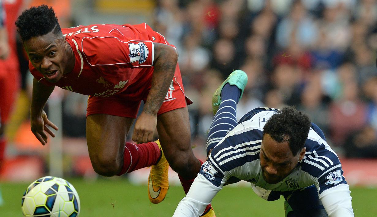Gelandang Liverpool, Raheem Sterling (kiri) berebut bola dengan bek West Bromwich Albion, Joleon Lescott pada laga Liga Inggris 2014/2015 di Anfield Stadium, Liverpool (4/10/2014). Raheem Sterling menjadi pemain Inggris termahal yang dilepas Liverpool, yaitu saat ia hijrah ke Manchester City pada awal musim 2015/2016 dengan nilai transfer 63,7 juta euro atau kini setara Rp1,04 triliun. Bersama Liverpool ia total tampil dalam 129 laga dengan torehan 23 gol dan 25 assist. (AFP/Paul Ellis)