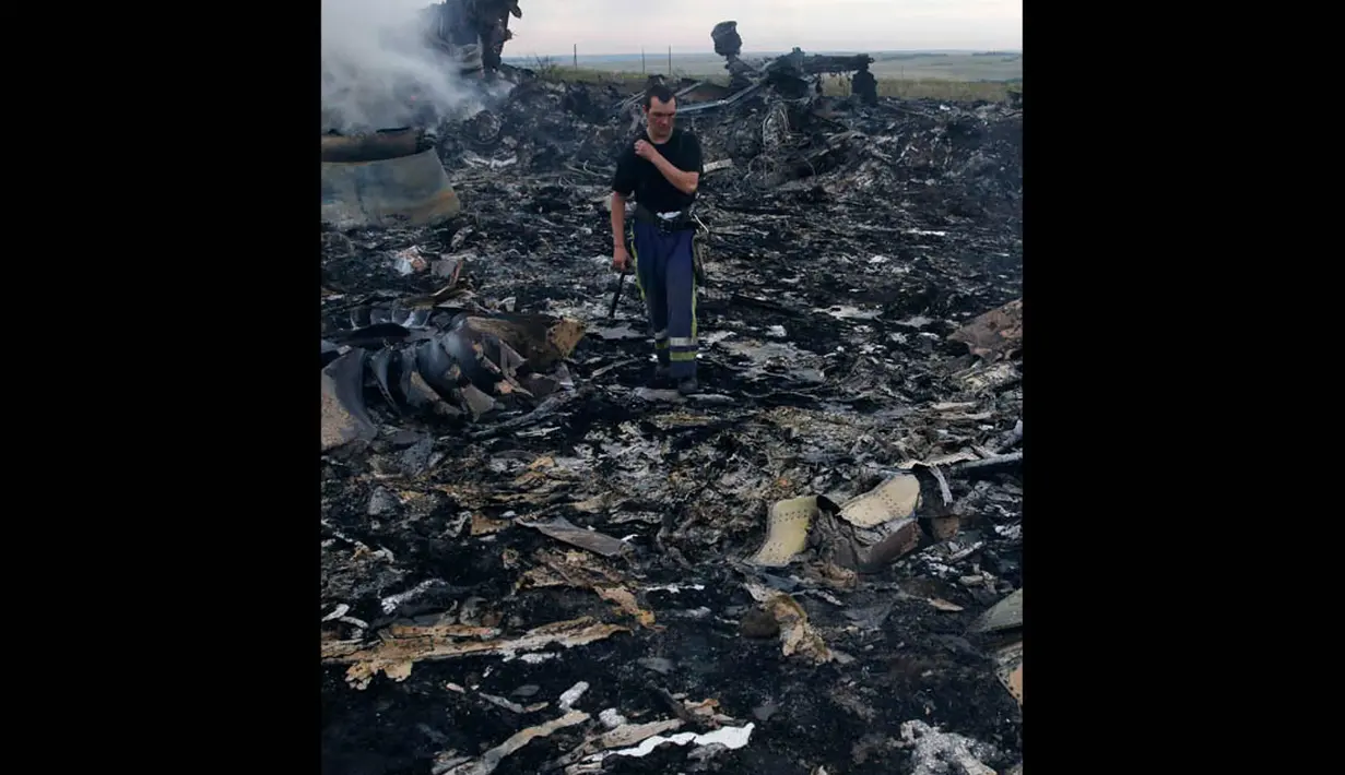 Petugas saat berada di puing-puing reruntuhan pesawat Malaysia Airlines MH-17 yang jatuh di Grabovo, wilayah Donetsk, Ukraina , Kamis (17/7/14). (REUTERS/Maxim Zmeyev)