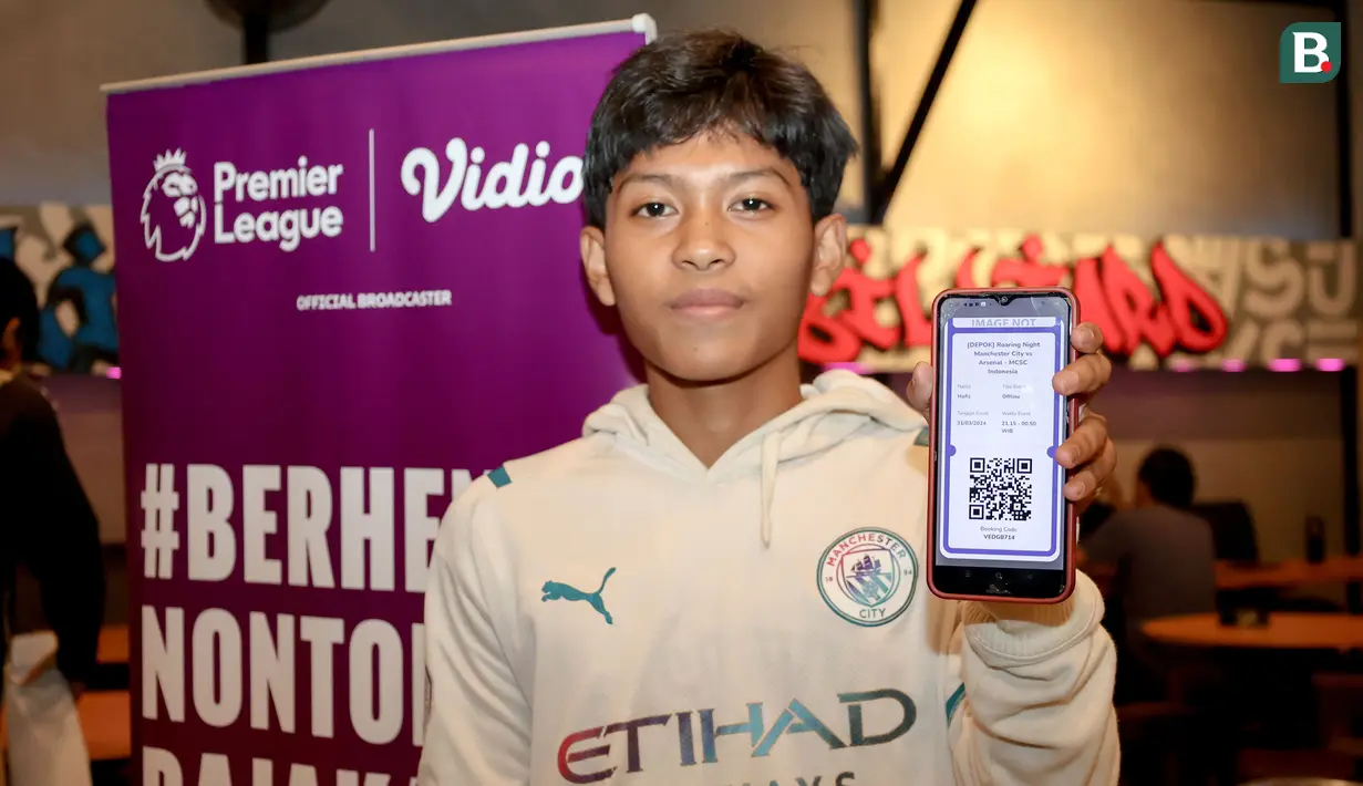 Seorang fans Man City memperlihatkan tiket pembelian Roaring Night Liga Inggris 2023/2024 antara Manchester City melawan Arsenal di Hype Cafe, Depok, Minggu (31/3/2024) malam. (Bola.com/Abdul Aziz)