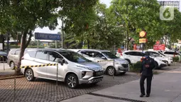 Petugas mengecek kendaraan yang parkir di Rest Area KM 13,5 Palm Square Tol Jakarta-Tangerang, Jumat (29/5/2020). Penerepan parkir berjarak dan pengecekan suhu tubuh di area tersebut diberlakukan untuk menekan penyebaran Covid-19. (Liputan6.com/Angga Yuniar)