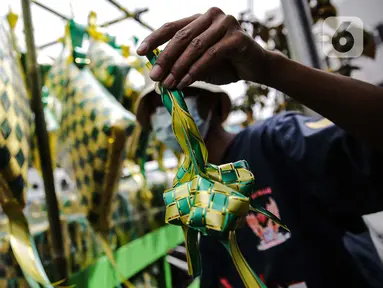 Pedagang memperlihatkan pernak-pernik ketupat hias dagangannya di Pasar Asemka, Jakarta, Selasa (4/5/2021). Pedagang mulai menjual pernak-pernik menjelang Lebaran seperti ketupat hias dengan harga mulai dari Rp15.000 hingga Rp60.000 tergantung ukuran. (Liputan6.com/Faizal Fanani)