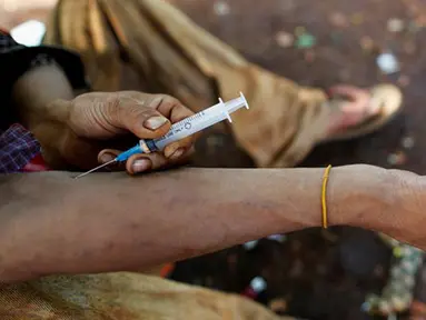 Seorang pria menyuntikkan heroin ke lengannya di sepanjang jalan Man Sam, Myanmar 11 Juli 2016. Sebanyak 42 ton sabu-sabu berhasil disita oleh kantor PBB untuk Narkoba dan Kejahatan (UNODC) pada 2013. (REUTERS/Soe Zeya Tun)