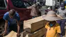 Sebuah mobil berhenti untuk memesan peti mati dari Mr. Jean dan timnya di jalan di Antananarivo, Madagaskar, Rabu (14/4/2021). Selama tiga minggu terakhir, Pak Jean dan timnya memproduksi antara 15 hingga 20 peti mati per hari, padahal sebelumnya hanya 3 atau 4 peti mati per hari. (RIJASOLO/AFP)