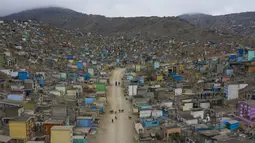 Pekerja pemakaman berjalan dengan anjing mereka di Pemakaman Nueva Esperanza, Lima, Peru, Minggu (1/11/2020). Untuk membantu mencegah penyebaran COVID-19, pihak berwenang menutup semua pemakaman secara nasional selama perayaan Day of the Dead. (AP Photo/Rodrigo Abd)