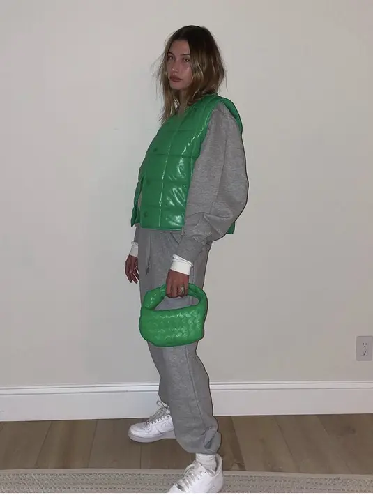 Hailey Bieber tampil sporty dengan hoodie dan pants abu-abu yang ia padukan dengan padding vest dan handbag hijau. Istri dari Justin Biaber ini pun mengkombinasikannya dengan sneakers putih dengan kaos kaki yang sedikit terlihat.(@haileybieber)