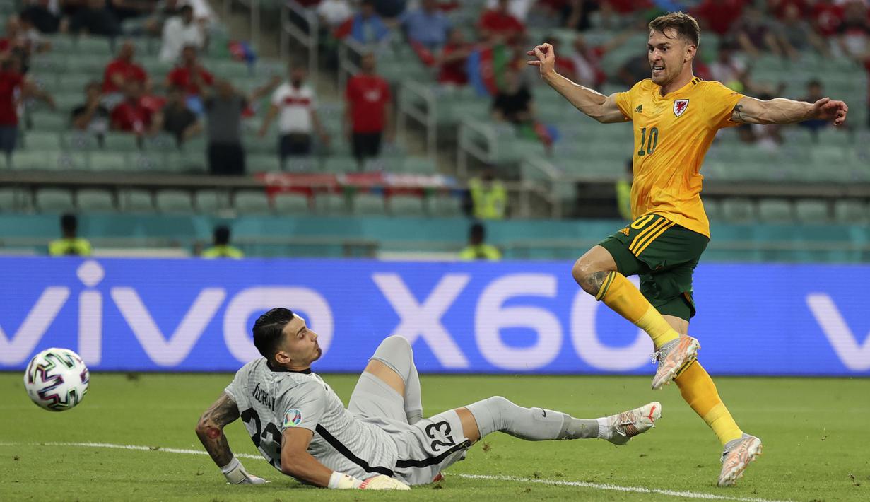 Kegagalan Aaron Ramsey akhirnya dapat dibayar ketika lagi-lagi umpan dari Gareth Bale berhasil dikontrol menggunakan dadanya, lalu ia ceploskan ke gawang melewati Ugurcan Cakir. Skor berubah 1-0 pada menit ke-42 dengan keunggulan Wales. (Foto: AP/Pool/Naomi Baker)