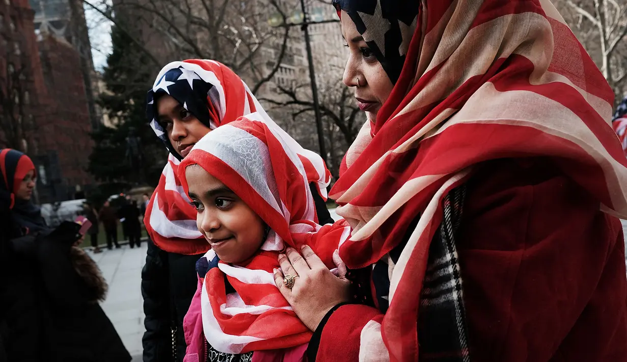 Sejumlah wanita memakai kerudung bermotif bendera AS selama perayaan Hari Hijab Sedunia di depan Balai Kota, New York, Rabu (1/2). Nazma Khan mengagaskan Hari Hijab Sedunia untuk menumbuhkan toleransi beragama. (Spencer Platt / Getty Images / AFP)
