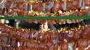 Seorang perempuan berdoa di depan deretan kertas untuk keberhasilan para siswa dalam ujian masuk perguruan tinggi di kuil Buddha Jogye, Seoul, Kamis (14/11/2019). Ujian masuk perguruan tinggi disebut-sebut sebagai ujian pertaruhan hidup para pelajar Korea Selatan. (Jung Yeon-je / AFP)