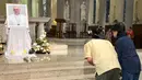 Umat berdoa di depan potret Paus Fransiskus di Katedral Maria Dikandung Tanpa Noda di Hong Kong pada 21 April 2025, setelah wafatnya Paus Fransiskus di Vatikan. (Peter PARKS/AFP)
