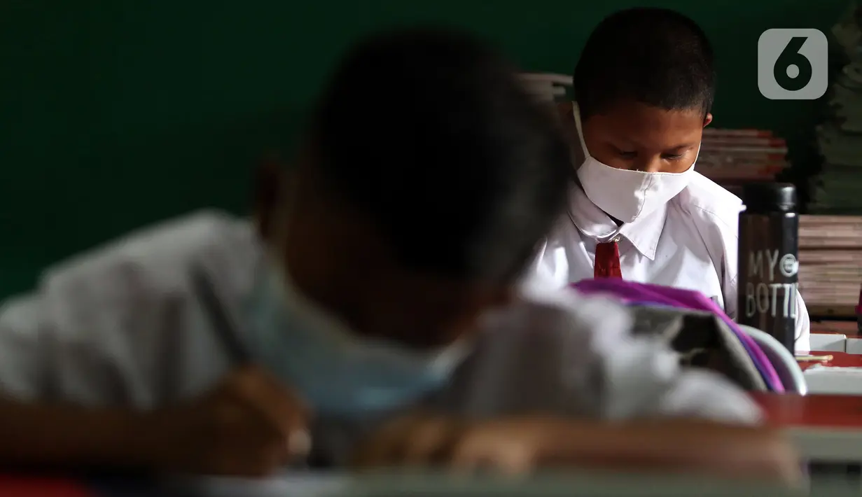 Murid SDN Kota Baru mengikuti ujian penilaian akhir sekolah di SDN Kota Baru 3 Bekasi, Jawa Barat, Senin (8/6/2021). Ujian dilaksanakan dengan pembatasan 50 persen jumlah murid tiap ruangan. (Liputan6.com/Herman Zakharia)