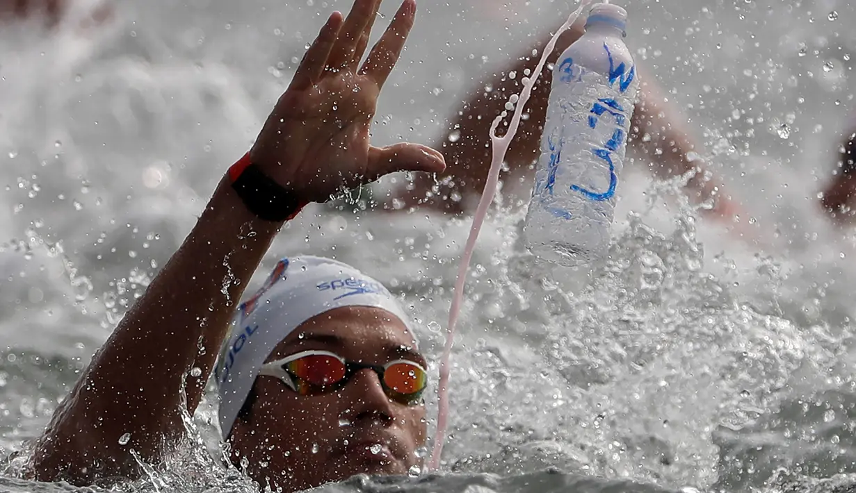 Perenang Spanyol Guillem Pujol melempar botol minuman saat berlaga dalam lomba renang air terbuka nomor 10 km putra di Kejuaraan Renang Dunia di Yeosu, Korea Selatan, Selasa (16/7/2019). (AP Photo/Mark Schiefelbein)