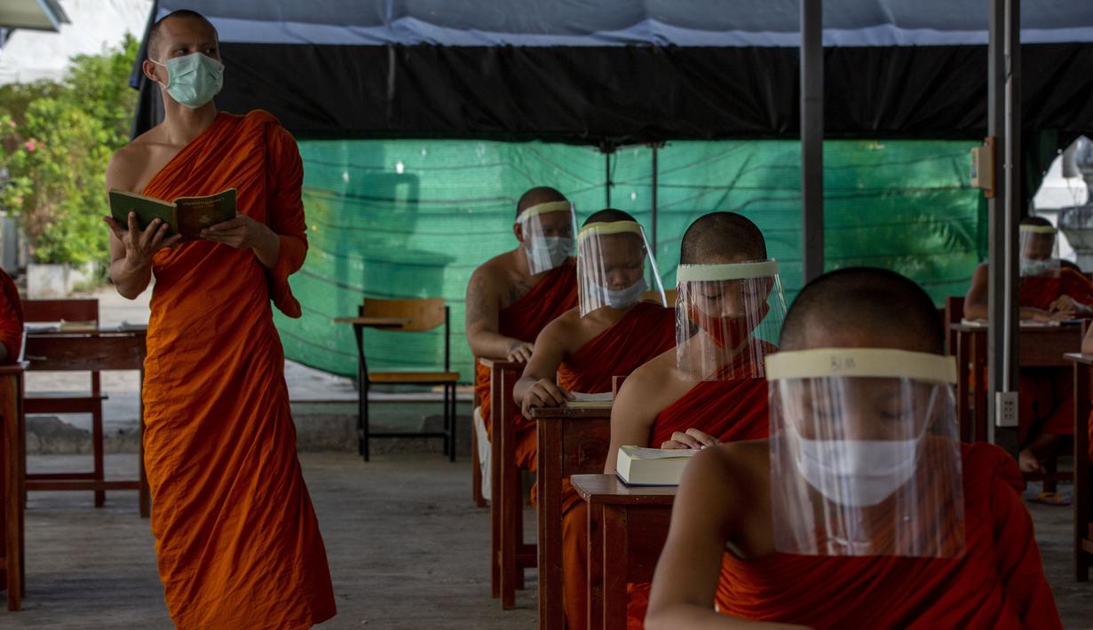 Para biksu muda mengenakan masker dan pelindung wajah saat belajar agama di Molilokayaram Educational Institute, Bangkok, Thailand, Rabu (15/4/2020). Sekitar 200 biksu muda tetap bersekolah kendati Thailand menutup semua sekolah selama lockdown akibat COVID-19. (AP Photo/Gemunu Amarasinghe)