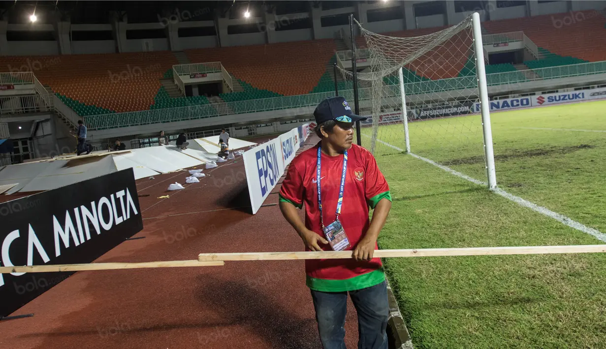 Pekerja mengukur pembatas saat persiapan jelang laga semifinal Piala AFF 2016 antara Timnas Indonesia melawan Vietnam di Stadion Pakansari, Jawa Barat, Jumat (3/12/2016). (Bola.com/Vitalis Yogi Trisna)