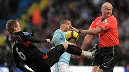 Duel gelandang Manchester City, Nigel de Jong, dengan gelandang Stoke, Glenn Whelan, hampir membuat wasit Lee Mason terkena tendangan pada laga boxing day Premier League di Stadion City Of Manchester, Inggris, Sabtu (26/12/2009). (AFP/Andrew Yates)