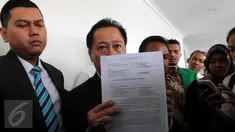 Ketua tim kuasa hukum PPP kubu Djan Faridz, Humphrey R Djemat menunjukkan sebuah dokumen usai sidang perdana di PN Jakarta Pusat, Selasa (15/3). Hakim menunda sidang gugatan terhadap Presiden Jokowi dan 2 menterinya tersebut. (Liputan6.com/Helmi Afandi)