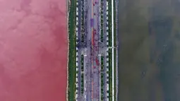 Pemandangan kontras air di sebuah danau garam yang dipisahkan oleh sebuah jalan di Yunchen, Shanxi, Tiongkok, Minggu (25/9). Fenomena aneh ini menjadi tontonan warga. (REUTERS/Wei Liang)
