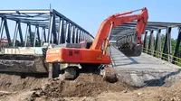 Sebuah alat berat menyelesaikan perbaikan jembatan yang amblas di jalur pantura Comal, Pemalang, Jateng. (ANTARA FOTO/Oky Lukmansyah)