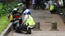Petugas kepolisian menggembosi ban motor yang parkir di trotoar Jalan Kebon Sirih, Jakarta, Senin (17/7). Hal ini tindak lanjut maraknya pelanggaran lalu lintas di kawasan pedestrian Jalan Kebon Sirih. (Liputan6.com/Helmi Fithriansyah)