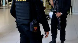 Dua personil kepolisian bersenjata berjaga di Bandara Ngurah Rai, Denpasar, Bali, Jumat (15/1). Pasca peristiwa serangan di Sarinah, Jakarta, pengelola Bandara Internasional I Gusti Ngurah Rai, Bali perketat pengamanan. (AFP PHOTO/Sonny Tumbelaka)