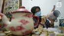 Perajin batik lukis ketel Nova Muhidir menyelesaikan lukisan batik di Studio Daroolang, Bintara, Tangerang Selatan, Banten, Rabu (2/12/2020). Lukisan ketel batik jadul khas nusantara di teko tempat air minum tersebut dijual dengan harga Rp 150 ribu hingga Rp 2,5 juta. (merdeka.com/Dwi Narwoko)