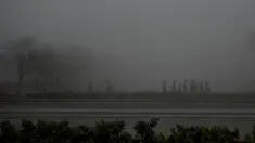 Orang-orang berjalan di sepanjang jalan di dekat gerbang India di tengah kabut asap tebal di New Delhi pada Rabu (22/2/2023). (Arun SANKAR/AFP)