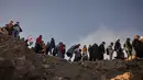 Para penganut Hindu dari komunitas Tengger mendaki gunung berapi aktif Bromo untuk mempersembahkan sesaji berupa beras, buah-buahan, ternak, dan barang-barang lainnya sebagai bagian dari festival Yadnya Kasada di dekat Probolinggo, Jawa Timur, Senin 1 Juni 2026. (JUNI KRISWANTO/AFP)