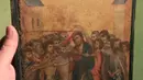 Pakar seni Stephane Pinta memperlihatkan lukisan “Christ Mocked” karya seniman Cimabue dari abad ke-13 di Paris, 24 September 2019. Lukisan berukuran 20 x 26 cm (10 inci) itu, diyakini sebagai bagian dari diptych yang terdiri dari delapan panel kecil. (AP/Michel Euler)