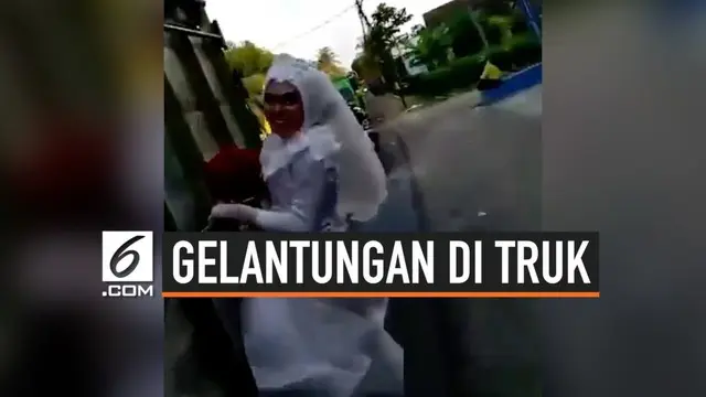 Sepasang pengantin melakukan aksi nekat yang mencuri perhatian warganet. Lengkap dengan pakaian pengantinnya, keduanya bergelantungan di sebuah truk yang sedang melaju.