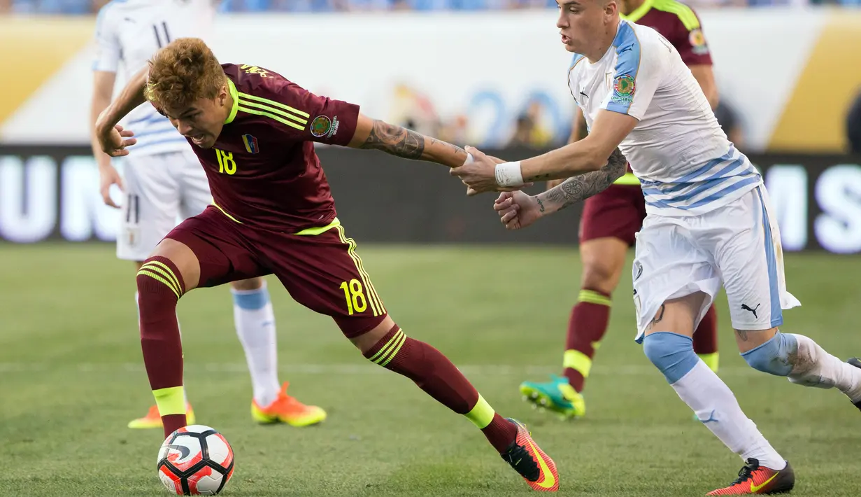 Gelandang Venezuela,  Adalberto Penaranda berusaha membawa bola dari kejaran bek Uruguay,  Jose Gimenez pada Copa America  Centenario 2016 di Lincoln Financial Field, AS (10/6). Venezuela menang atas Uruguay 1-0. (Bill Streicher-USA TODAY Sports)