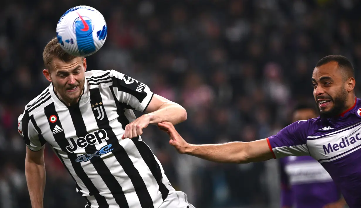 Bek Juventus, Matthijs de Ligt (kiri) menyundul bola di depan striker Fiorentina, Arthur Cabral pada laga leg kedua semifinal Coppa Italia 2021/2022 di Juventus Stadium, Turin (20/4/2022). Matthijs de Ligt hingga kini menjadi pemain termahal yang dijual Ajax ke Serie A di Liga Italia. Pemain Timnas Belanda ini didatangkan Juventus dari Ajax pada awal musim 2019/2020 dengan nilai transfer mencapai 85 juta euro atau kini setara Rp1,39 triliun. (AFP/Marco Bertorello)