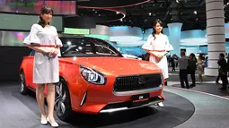 Dua model berpose di dekat mobil Daihatsu DN Compagno selama Tokyo Motor Show di Tokyo, Jepang (25/10). Pameran ini digelar dari 25 Oktober sampai 5 November 2017. (AFP Photo/Toshifumi Kitamura)