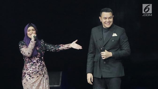 Penyanyi Siti Nurhaliza (kiri) berduet dengan Tulus dalam konser 'Dato Sri Siti Nurhaliza on Tour' di Istora Senayan, Jakarta, Kamis (21/2). Tulus undur diri dari panggung setelah membawakan lagu 'Sewindu'. (Fimela.com/Bambang E Ros)