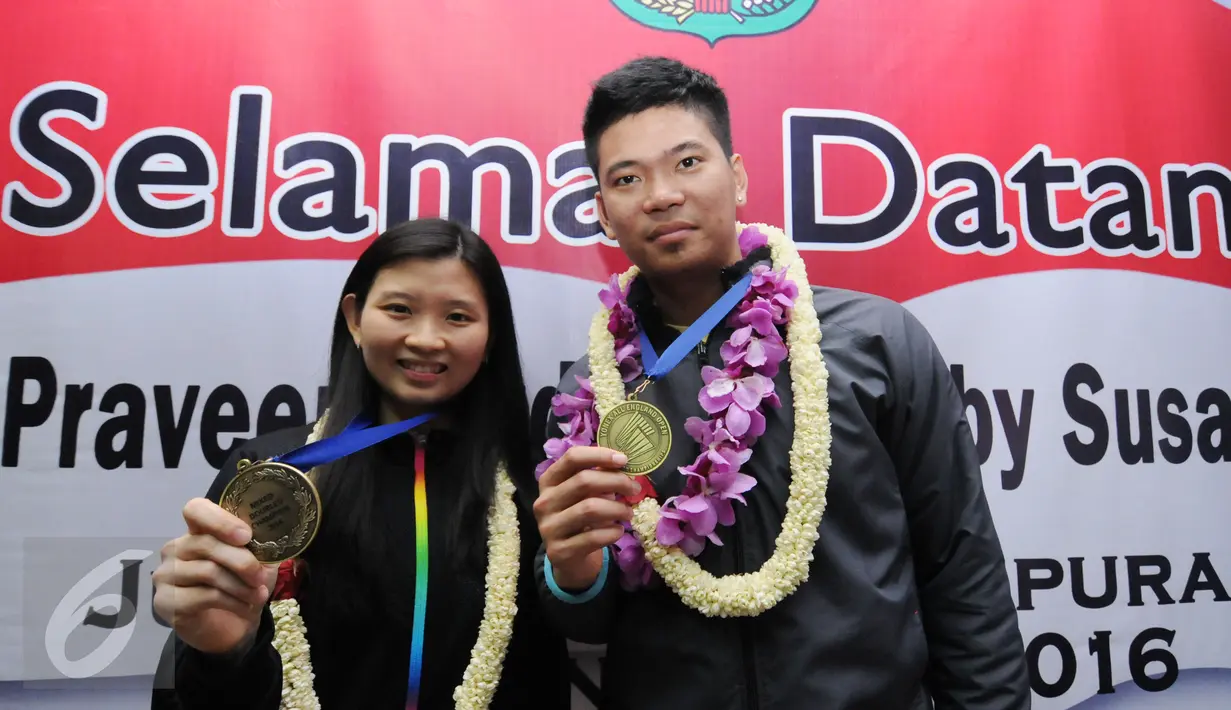 Praveen Jordan/Debby Susanto memamerkan medali emas All England 2016 di Bandara Soetta, Banten, Rabu (16/3/2016). Praveen/Debby menjadi juara usai mengalahkan pasangan Denmark, Joachim Fischer Nielsen/Christinna Pedersen. (Liputan6.com/Helmi Fithriansyah)