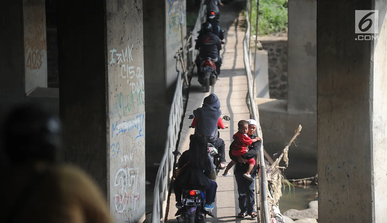 Pengendara motor melewati jembatan Ciliwung yang berada di bawah tol ruas Gadog, Ciawi, Bogor (16/68). Jembatan ini menjadi jalan alternatif bagi pemotor untuk menghindari kemacetan lalu lintas. (Merdeka.com/Arie Basuki)