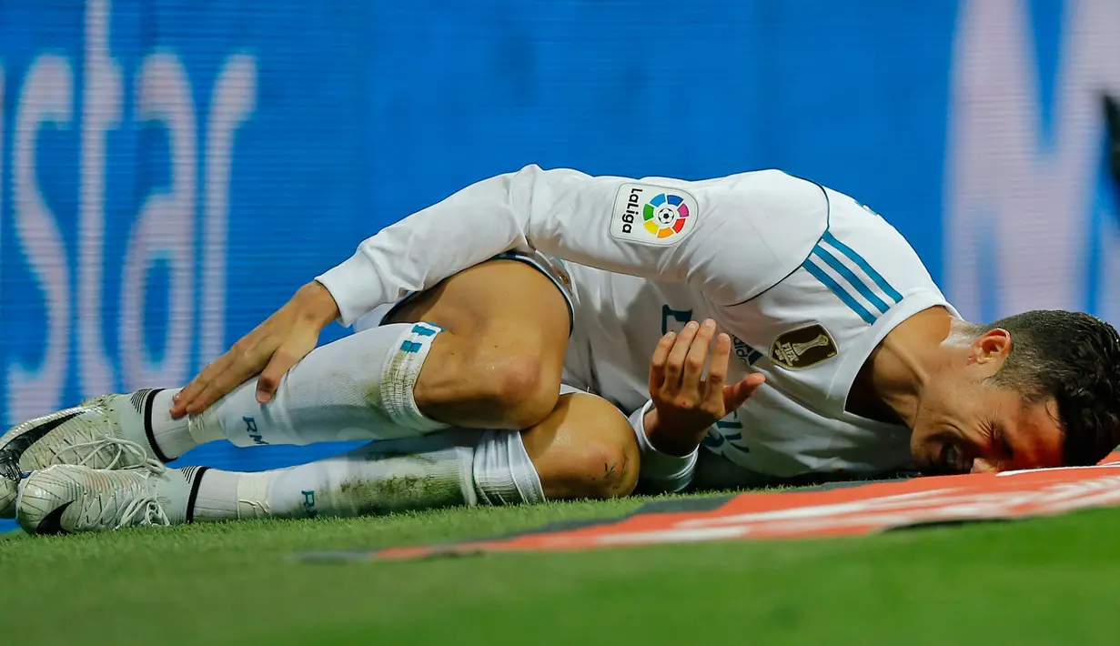 Pemain Real Madrid, Cristiano Ronaldo tergeletak di lapangan setelah terjatuh dalam lanjutan La Liga 2017/2018 melawan Espanyol di Santiago Bernabeu, Minggu (1/10). Real Madrid sukses menundukkan Espanyol dua gol tanpa balas. (AP/Paul White)