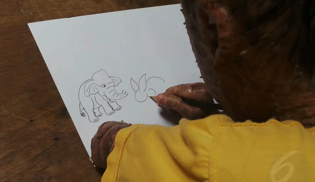 Menggambar di atas kertas menjadi salah satu kegemaran Ari Wibowo di sela-sela waktunya menjaga warnet. (Liputan6.com/Benedikta Desideria)