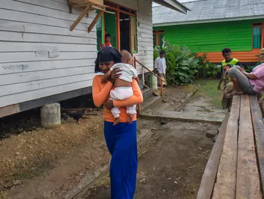 Pengungsi wanita menggendong anaknya di kompleks penampungan sementara Blang Adoe, Aceh Utara, Aceh, Rabu (27/4). Tersisa 300 orang pengungsi Rohingya di empat penampungan kabupaten/kota Pantai Utara dan Timur Aceh. (Chaideer Mahyuddin / AFP)