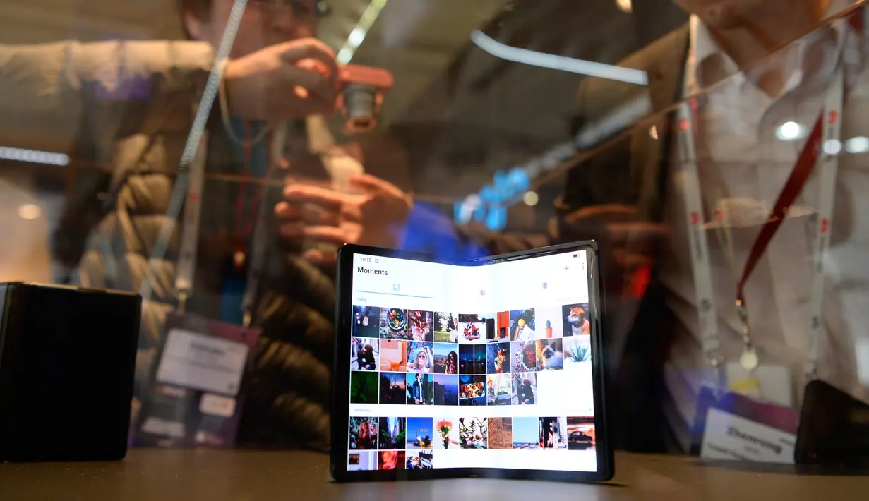 Pengunjung melihat smartphone TCL's DragonHinge yang ditampilkan dalam gelaran Mobile World Congress (MWC) 2019, Barcelona, Spanyol, Rabu (27/2). Perusahaan fokus pada layar yang dapat dilipat dan pengenalan jaringan nirkabel 5G. (Photo by Josep LAGO/AFP)