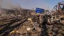 Pemandangan sebuah mobil yang hancur di tengah bangunan-bangunan yang rusak, serta rambu jalan yang menunjukkan arah dan jarak ke Kyiv dan Zhytomyr, setelah serangan Rusia menghantam sebuah gudang yang kemudian disusul oleh ledakan di desa Myla, wilayah Kyiv, Ukraina, Sabtu, 29 Agustus 2026. (Foto AP/Dan Bashakov)