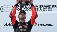 Pembalap Aprilia Racing asal Italia, Marco Bezzecchi, merayakan kemenangan di podium setelah menjuarai balapan MotoGP Indonesia di Sirkuit Internasional Mandalika, Mandalika, Minggu (11/10/2026). (SONNY TUMBELAKA/AFP)