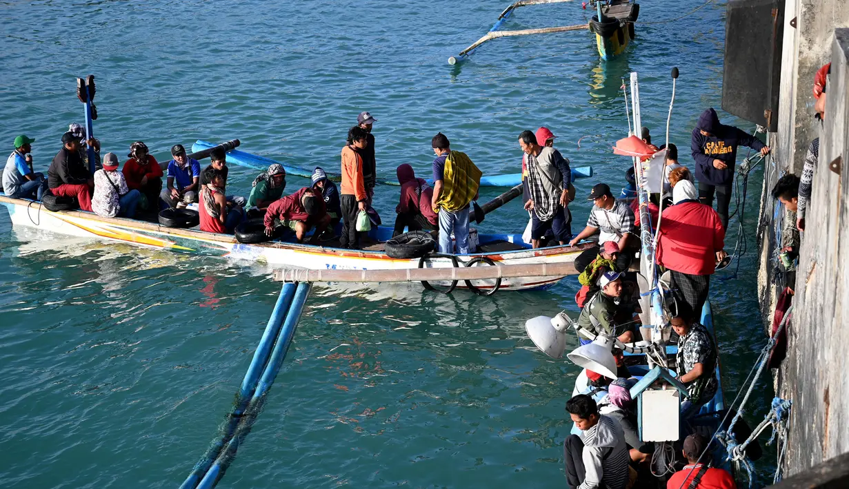 Sejumlah nelayan berbincang sebelum pergi memancing di Kedonganan, Denpasar, Bali (15/7/2019).  Desa Kedonganan terkenal dengan sektor Perikanan, dan juga Pantai Kedonganan yang indah. (AFP Photo/Sonny Tumbelaka)