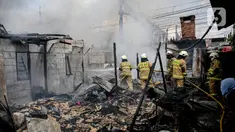Petugas pemadam kebakaran menyemprotkan air untuk memadamkan api saat terjadi kebakaran di Jalan Kampung Muka, Pademangan, Jakarta, Selasa (25/4/2023). (Liputan6.com/Faizal Fanani)