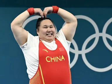 Lifter China, Li Wenwen melakukan selebrasi dengan membuat gestur hati setelah memastikan dirinya meraih medali emas cabang olahraga angkat besi +81kg putri Olimpiade Paris 2024 di South Paris Arena, Paris, Prancis, Sabtu (11/08/2024). Li Wenwen berhasil mempertahankan gelarnya di Olimpiade Paris 2024 setelah melakukan angkatan 309kg, dengan rincian 136kg snatch dan 173kg clean and jerk. (AFP/Arun Sankar)