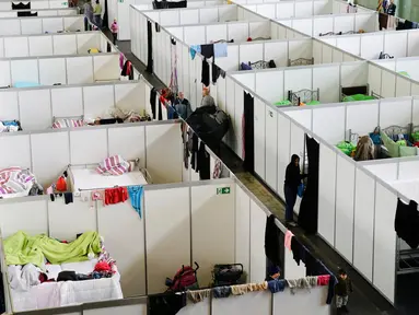 Pemandangan deretan ruang tidur bagi para migran di dalam hanggar bekas bandara Tempelhof di Berlin, Jerman, Rabu (9/12/2015). Jerman menerima satu juta migran dari beberapa negara yang sedang dilanda perang. (REUTERS/Fabrizio Bensch)