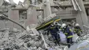 Petugas pemadam kebakaran membawa mayat dari puing-puing gedung pemerintah yang terkena roket Rusia di Mykolaiv (29/3/2022). Serangan Rusia menghancurkan gedung pemerintah daerah di kota Mykolaiv, Ukraina selatan, pelabuhan utama yang diserang selama berminggu-minggu. (AFP/Bulent Kilic)